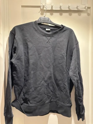 Svart sweatshirt från Zara - En stilren svart sweatshirt från Zara i storlek L. Tröjan har rund halsringning, långa ärmar och ribbade muddar vid ärmslut och nederkant. Perfekt för en avslappnad och trendig look. Tillverkad i mjukt material för extra komfort.