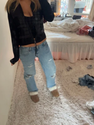 Baggy jeans Levis med hål  - Säljer ett par ljusblå jeans med raka/ baggy ben och slitningar på både lår och knän. Jeansen har en klassisk femficksmodell och är i en loose passform. Perfekta för en avslappnad och trendig look.