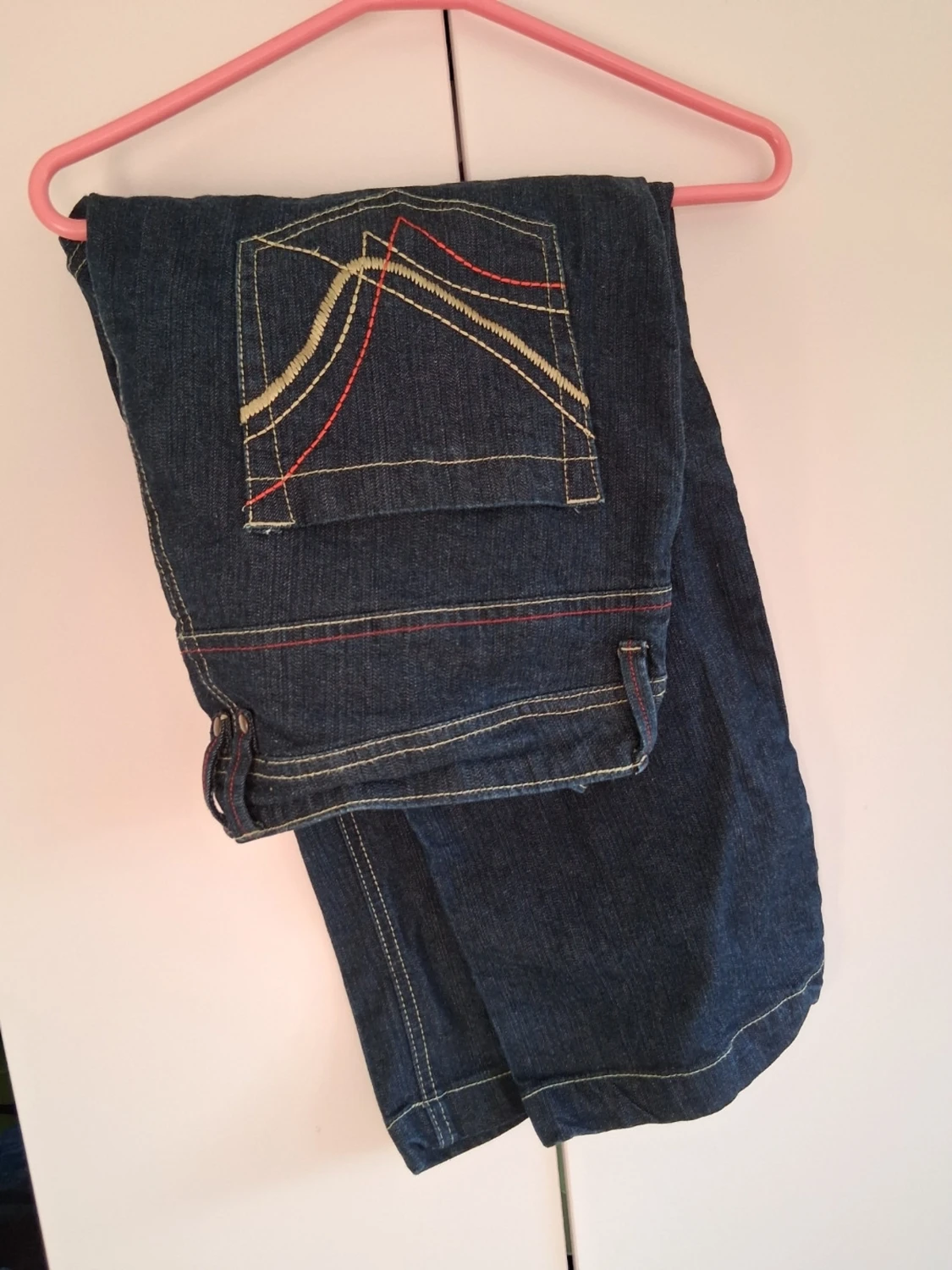 Mörkblå jeans med färgglada sömmar