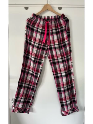 Rutiga Victoria’s Secret pyjamasbyxor, XS - Snygga byxor / loungebyxor / pyjamasbyxor / mjukisbyxor från Victoria’s Secret i storlek XS. Klassiskt rutigt mönster i rosa, svart och vitt. Byxorna har en elastisk midja med en dekorativ dragsko i starkt rosa. Bensluten är raka med en snygg rosa kantdetalj. Bomull och modal-blandning, så bra material som andas. Mycket gott skick!