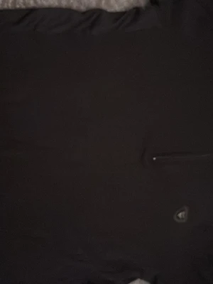 Svart Armani Piké - En stilren svart t-shirt med en diskret bröstficka och liten logga på framsidan. T-shirten har klassisk passform och rund halsringning. Perfekt basplagg för alla tillfällen.