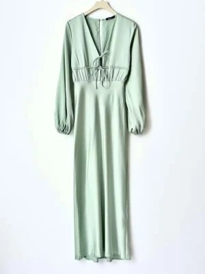 Elegant långklänning i satin  - En slutsåld favorit-mycket fin ljusgrön långklänning i mjuk satin med lång ärm och smickrande v-ringning. Klänningen har ryschade detaljer och ett charmigt knytband framtill som framhäver midjan. En riktig pärla– perfekt för fest, bröllop eller en extra speciell kväll! 🌸 Ord pris 999 kr  