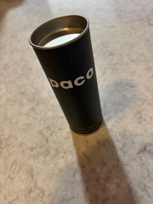 Paco Eau de Toilette 100 ml - Säljer en stilren parfym från Paco Rabanne, Eau de Toilette Natural Spray i svart cylinderformad förpackning med vit text. Flaskan rymmer 100 ml och har en modern, minimalistisk design som känns både klassisk och trendig.