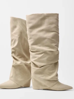 Beige stövlar Nelly - Säljer ett par beige slouchy stövlar med spetsig tå. Stövlarna har en mjuk, rynkad design i mocka som ger en trendig och avslappnad look. Perfekta för dig som vill sticka ut med en unik siluett och cool vibe. Från nelly. Storlek 38! Helt nya i förpackning💞Nypris är 899kr