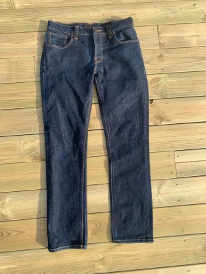 Nudie jeans  - Säljer ett par mörkblå jeans från Nudie modellen är Grim Tim, de är i mycket bra skick, som nya. Storleken är W33 och L 32. Hör av dig vid frågor och funderingar 