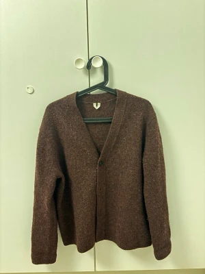 Vinröd cardigan  - Vinröd cardigan från Arket i storlek small. Använts  ett fåtal gånger och är i väldigt bra skick. Perfekt nu inför våren!