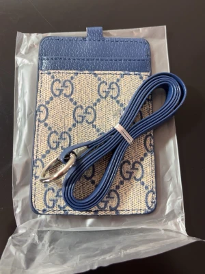 GG Plånbok med band - • Säljer denna helt nya, oanvänd  • GG plånbok med band runt halsen • Beige och blå • Top kvalité    Har 2 st.          2 ST FÖR 500