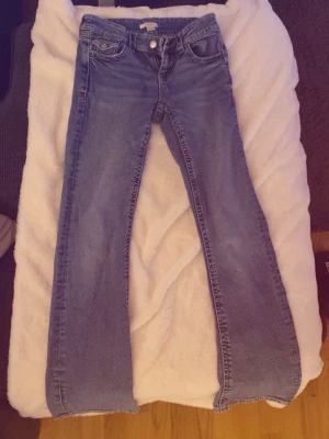 Blå bootcut jeans med stretch - Säljer ett par klassiska blå bootcut jeans med stretch. Jeansen har fem fickor, normal midja och dragkedja med knapp.