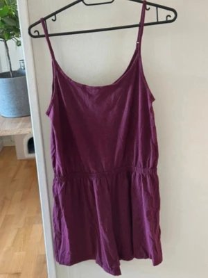 Vinröd jumpsuit från H&M storlek s - Säljer en vinröd jumpsuit från Divided med tunna axelband och avslappnad passform. Tillverkad i mjukt tyg, perfekt för sommardagar. Enkel och stilren design som är lätt att matcha med sneakers eller sandaler. Använd men i bra skick 