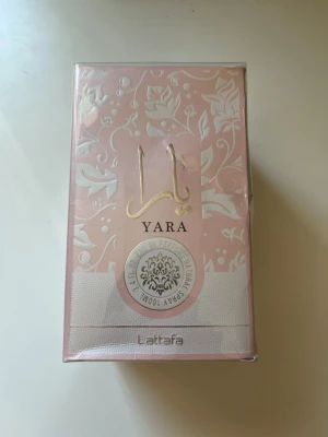 Yara parfym från Lattafa - Helt ny Yara parfym från Lattafa i en elegant ljusrosa förpackning med blommigt mönster och gulddetaljer. Doften är en eau de parfum och flaskan har en lyxig känsla som passar dig som gillar unika och trendiga parfymer. Hör av er vid minsta lilla fråga och priset kan diskuteras 