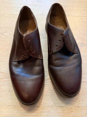 Bruna loafers från G.H. Bass & Co. - Säljer ett par klassiska bruna loafers från G.H. Bass & Co. i äkta läder. Skorna har en stilren design med rundad tå och diskreta sömmar. Perfekta för dig som gillar tidlös och enkel stil. Innersulan är märkt med Bass-loggan. Skosnören saknas 