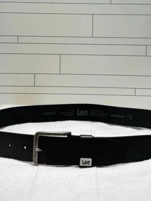 Svart skärp i skinn från Lee - Snyggt svart bälte från Lee i äkta skinn med klassiskt silverfärgat spänne och diskret Lee-logga på hällan. Perfekt för att lyfta vilken outfit som helst med en stilren touch.