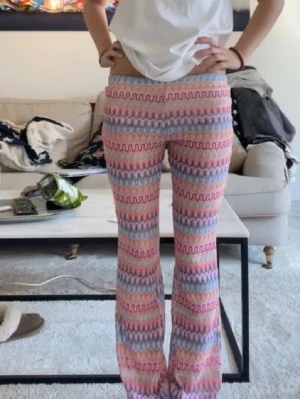 Orrebyxor - Säljer ett par utsvängda leggings med vågigt mönster i rosa, blått, lila och vitt. 