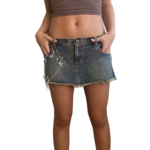 Snygg lågmidjad minikjol 2000s Y2K Vibes  - Lågmidjad jeans minikjol 2000s med kedjor paljetter  pärlemo i sidan . kjolen är ny så fint skick💕