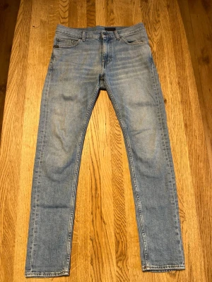 Ljusblå tiger of Sweden/jeans - Snygga ljusblå slim fit jeans med klassisk femficksdesign och normal midja. Jeansen har en lätt tvättad look och raka ben. Perfekta för en avslappnad och trendig stil.