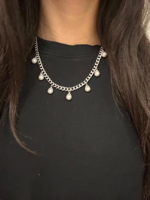 Silverfärgat 6mm bred halsband med  pärlor - Elegant halsband i silverfärgat rostfritt stål från Diavansa – finns även i guldpläterad variant. Matchande örhängen finns i en separat annons.  Smycket är 6 mm brett och har en justerbar längd mellan 42–50 cm, vilket gör att det passar perfekt oavsett stil och tillfälle. Nickeltestad och handgjort.