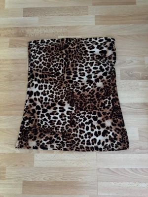 Leopardmönstrad kortkjol i fleece - Cool kortkjol med leopardmönster i bruna och svarta toner. Kjolen är lätt utsvängd och gjord i mjuk fleece som känns skön mot huden. Perfekt för dig som vill sticka ut med en trendig och djärv look. Storlek lapp avklippt, använd en gång.