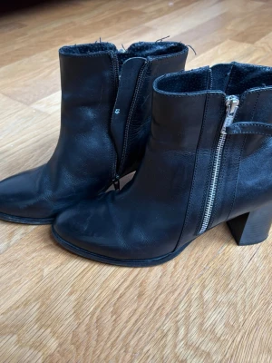 Ankelhöga boots - Dekorationsdragkedja på utsidan. Äkta läder. Använda en gång.