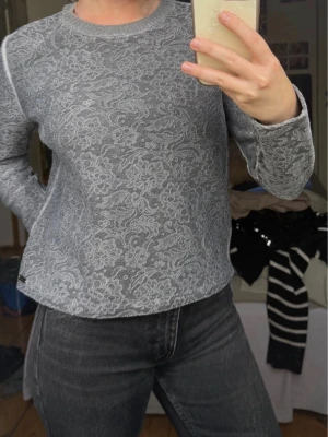 Grå sweatshirt  - Grå sweatshirt från Hugo boss, storlek s. Har lite defekter men inget som förstör ”the overall appearance”. Den är av den äldre modellen, så mer vinted. Fina detaljer med blommor på hela tröjan. 