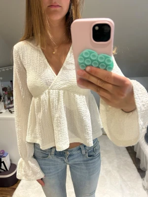 vit blus med volangärmar 💛💛 - superfin vit blus med v-ringning och voluminösa långärmade ärmar. blusen har en strukturerad, lite bubblig textur och ett flowy fall nedtill. perfekt att styla med jeans eller kjol för en trendig look. från gina tricot i stl xs/s endast använd ett fåtal gånger och har inga tecken på användning!! hör av dig vid frågor ☺️använd gärna ”köp nu”