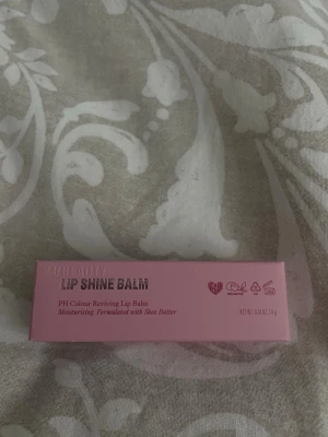Lip Shine Balm Toffee Temptation - Lip Shine Balm från MMBeauty i färgen Toffee Temptation. Läppbalsamet är återfuktande och innehåller sheasmör. Kommer i en rosa förpackning och ger en naturlig glans till läpparna. 