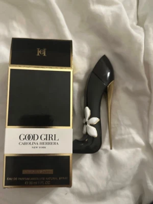 Good Girl parfym från Carolina Herrera - Säljer en Good Girl parfym från Carolina Herrera i en unik flaska formad som en svart stilettklack med gulddetaljer och en vit blomma. Flaskan rymmer 30 ml och har en lyxig och elegant design som sticker ut i parfymhyllan. OBS! Helt ny, jag använder den tyvärr inte. Kommer inte gå ner i pris tyvärr.