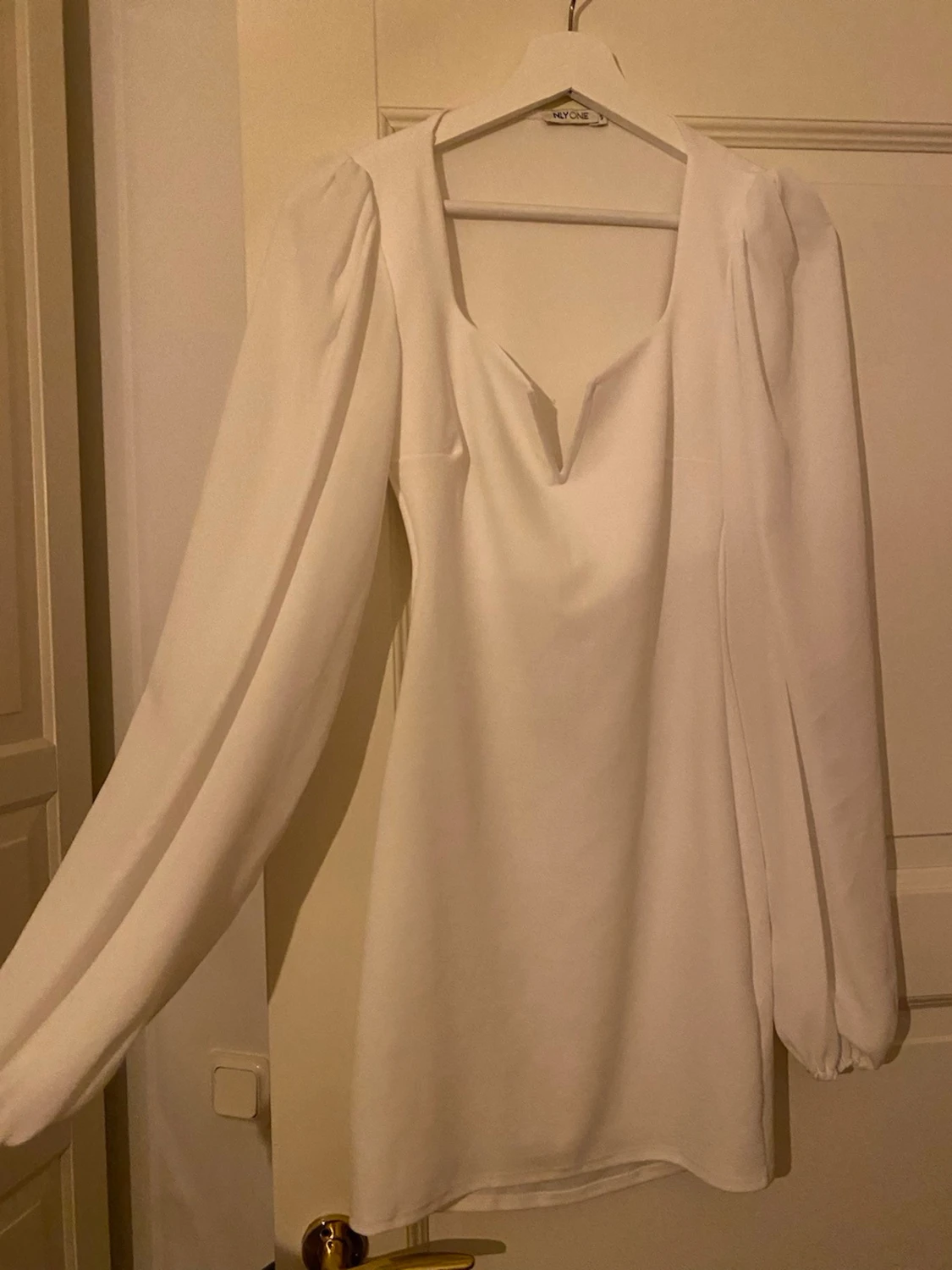 Vit långärmad klänning.