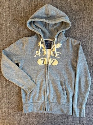 American eagle zip tröja - sällsynt  - Eftertraktad American Eagle zip-tröja, tidlös modell i fint skick. Perfekt för vardag och casual outfits.  • Storlek: S • Skick: Väldigt bra • Modell: Zip-tröja • Material: Mjukt, bekvämt och välbevarat  Varför den är unik: – Klassisk American Eagle-design som alltid håller – Smidig zip-modell som är lätt att styla – Perfekt basic-plagg som funkar året runt  Skickas snabbt och tryggt 📦 inom 24h 