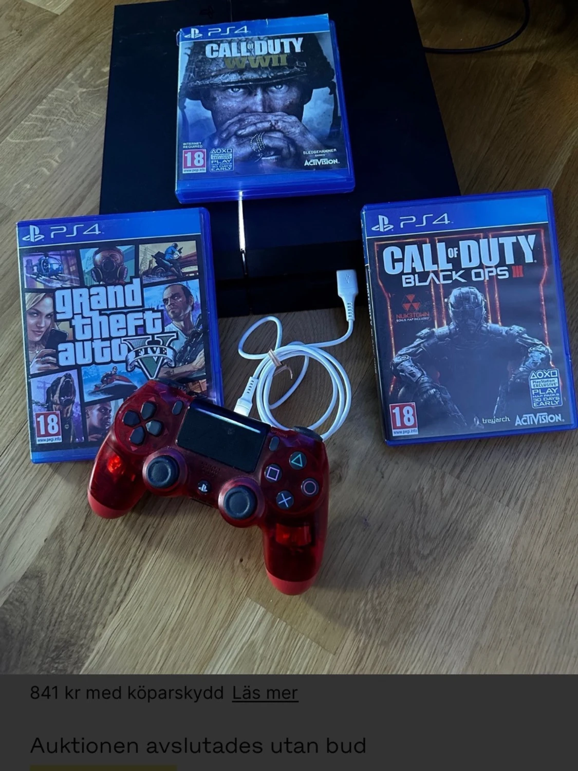 PlayStation 4 med spel och röd handkontroll