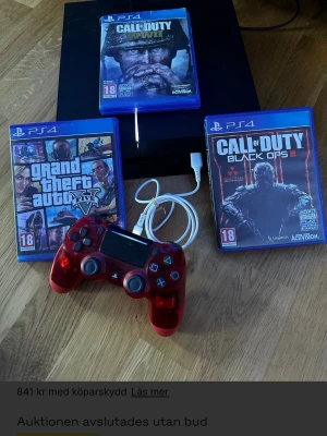 PlayStation 4 med spel och röd handkontroll - PlayStation 4-konsol i svart med en transparent röd DualShock 4-handkontroll, laddkabel och tre PS4-spel: Grand Theft Auto V, Call of Duty Black Ops III och Call of Duty Modern Warfare. Perfekt för gaming med vänner.