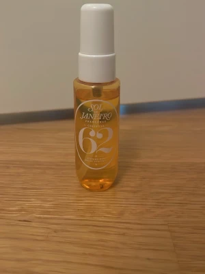 Sol de Janeiro Cheirosa 62 Parfym - Sol de Janeiro Cheirosa 62 är en parfym i en genomskinlig, cylinderformad plastflaska med vit spraykork. Flaskan har en varm gul-orange tonad vätska och tydlig logga framtill. Doften är inspirerad av brasiliansk sommar och har en fräsch, söt karaktär.