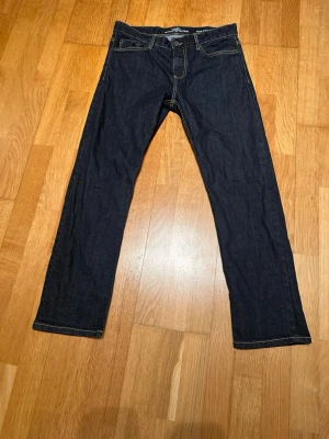 Mörkblå regular fit jeans Hampton Republic  W32 L30 - Snygga mörkblå jeans från Hampton Republic i modellen Hank Regular Fit. Klassisk femficksdesign med kontrastsömmar och rak passform. Perfekta till vardagslooken och tillverkade i slitstarkt denimtyg.