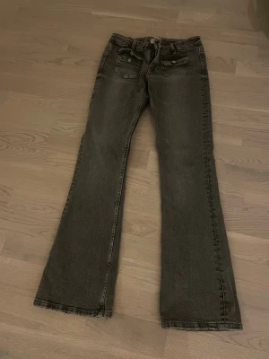 Grå lågmidjade bootcut jeans  - Säljer ett par grå bootcut . Perfekt för dig som gillar en avslappnad men ändå trendig look.