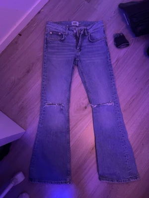 Blå bootcut jeans hål  från 157 - Säljer ett par blå bootcut jeans från 157 med slitna knän och klassisk femficksdesign. Jeansen har utsvängda ben och är tillverkade i denim med snygg tvätt. Perfekta för en avslappnad och trendig look.