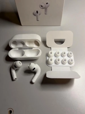 AirPods Pros 3 - Säljer ett par  Pro 3 i vit färg med matchande laddningsetui och extra silikonpluggar i olika storlekar. Hörlurarna har en stilren, kompakt design och är tillverkade i blank plast. Perfekta för trådlös musik och samtal.