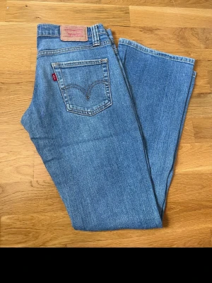 Levi's ljusblå bootcut jeans - Säljer ett par klassiska ljusblå Levi's jeans med bootcut passform och låg midja. Passar någon under 160cm
