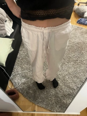 Rosa linnebyxor med resårmidja - Säljer ett par rosa linnebyxor med avslappnad passform och resår i midjan. Byxorna har raka ben och är perfekta för en chill och luftig stil. Materialet är linne vilket gör dem svala och sköna. Passar perfekt till sommaren!