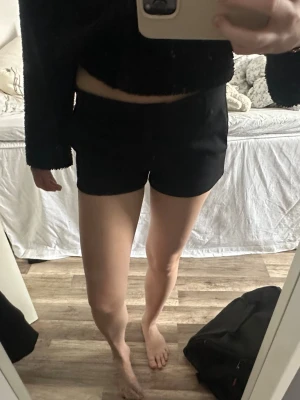 Svarta shorts med normal passform - Snygga svarta shorts med klassisk design och normal passform. De har en enkel look utan synliga detaljer och passar perfekt till sommaren. Tillverkade i ett mjukt och bekvämt material.