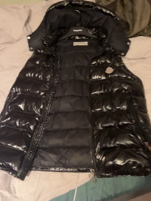 Moncler väst - Hej, säljer denna monclizzy väst eftersom den är lite stor i midjan och letar efter en ny stil, västen är i nästan perfekt kondition förutom att fickan på insidan vid bröstet går ej att stänga eller öppna, hör bara av er om ni är intresserade🥰😉😎