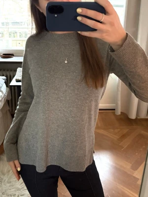 Grå tröja 100% kashmir - Säljer denna grå 100% kashmir tröja. Den har så fin passform och har slits på sidorna! Passar mig som vanligtvis bär S