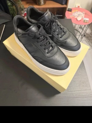 Axel Arigato Orbit Vintage Sneaker – Svart/Vit 44 - Säljer ett par stilrena Axel Arigato Orbit Vintage Sneakers i svart läder med vit sula. Skorna är i fint begagnat skick och passar lika bra till jeans som till mer uppklädda outfits.  * Modell: Axel Arigato Orbit Vintage Sneaker * Färg: Svart/Vit * Material: Premiumläder * Skick: Fint begagnat skick, se bilder * Originalkartong medföljer  Nypris cirka 2 850 kr.  Pris: 1 400 kr eller bud.
