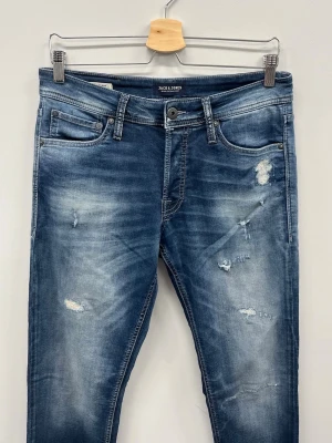 Jack & Jones Slim fit Glenn - Modell: Slim Fit / Glenn Färg: Mörkblå denim med distressed-detaljer Storlek: 32/34  Skick: Använda några gånger, inget extra slitage utöver fabriksdetaljerna. Bra skick generellt. Pris: 399 kr