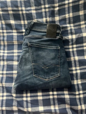 Replay Anbass jeans  - Replay Anbass jeans, hål i knä samt skrevet men det är ej synligt när du bär dem! JAG SKICKAR EJ FLER BILDER PÅ JEANSEN! för storleksguide hänvisar jag till måtten och för bättre inblick i passformen rekommenderar jag att googla på modellnamnet.JAG TAR EJ EMOT RETURER. kom ej med bud om du ej köper efter:)