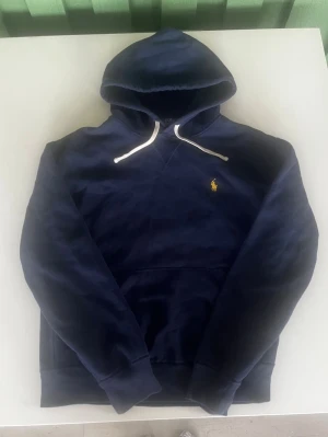 Ralph lauren hoodie mörkblå  - Riktigt snygg och eftertraktad Ralph lauren hoodie i mörkblå färg. fint skick inga fel storlek S/M passar 166-176 mc för mellan kan ta mått vid behov. Endast 428kr ej hugget i sten kom gärna med frågor och prisförslag har även mycket mer liknande i min profil alla storlekar kolla gärna stor rabatt vid köp av flera 😁✌️