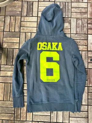 Mörkblå Superdry Osaka hoodie - Fin Superdry Osaka hoodie. Storlek M men passar mer Xs eller S. Längd 62cm, axel till axel 44cm. Skriv gärna vid frågor!