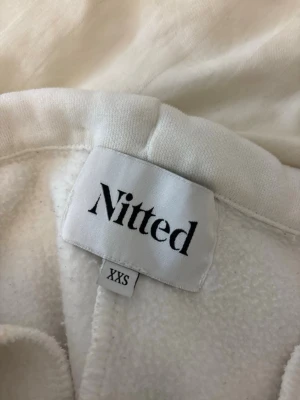 Vita mjukisbyxor från Nitted - Säljer ett par vita mjukisbyxor från Nitted i storlek XXS. Byxorna har dragsko i midjan med metalländar och är gjorda i ett mjukt, fleeceliknande material. Perfekta för en chill och avslappnad stil.