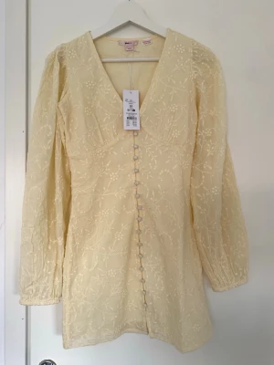 Ljusgul blommig klänning från Gina Tricot - Superfin populär ljusgul kortklänning från Gina Tricot young 14+ med broderat blommönster, v-ringning och långa puffärmar. Tyvärr för liten för mig. HAR ÄVEN EN I STORLEK S PÅ MIN PROFIL🌸💞