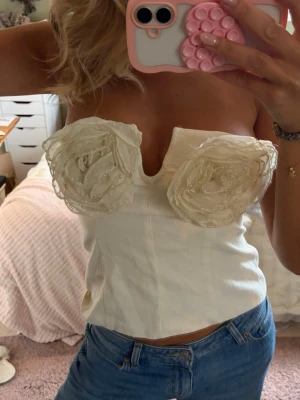 Vit axelbandslös korsettopp med rosor - Supercool topp med rosor!! Endast använd 1 gång! Toppen stängs med dragkedja bak💖💖