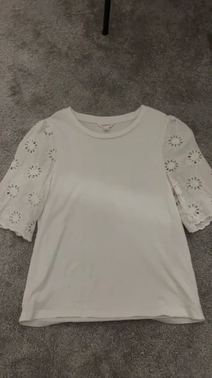 dobber vit topp - dobber vit t-shirt med blom hål-ärmar. köpt på MQ för drygt 500kr, mycket bra skick förutom en ytterst liten fläck (prick) nere i vänstra hörnet. ingenting man ser på håll💓 storlek xs och säljs p.ga att den inte kommer till användning💕