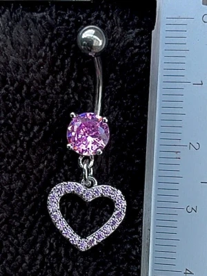 NY oanvänd Navelpiercing med hänge | Kirurgiskt stål | Hjärta och rosa stenar  - 💕30% Bundle-rabatt vid köp av minst 2 artiklar. ⭐️NY oanvänd piercing i kirurgiskt stål; rostfritt och säkert för läkta piercingar.                               📏MÅTT ⭕️Stavens längd: 10mm ⭕️Stavens tjocklek: 1,6mm ⭕️Smyckets totala längd: 35mm                                                                         🤍Färger: Silver och rosa                                                            💌Skickas spårbart via Plick SafePay.